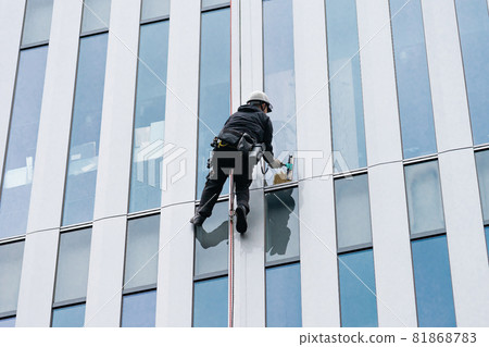 Cleaner polishing windowpanes of skyscrapers 81868783
