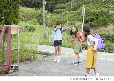 Elementary school students walking on the school road 81871738