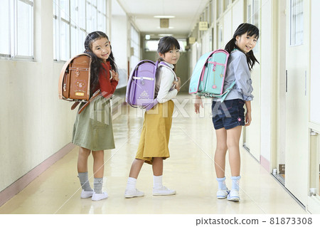 Girl carrying a school bag in the school corridor Girl carrying a school bag in the school corridor 81873308