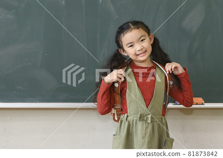 Elementary school students greet in front of the blackboard in the classroom Elementary school students greet in front of the blackboard in the classroom 81873842