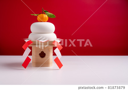 Photograph taken with Kagami mochi on the left and against a red and white background, with three treasures (pedestal) 81873879