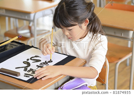 Studying penmanship in the classroom, elementary school girl, writing with a tiger year Studying penmanship in the classroom, elementary school girl, writing with a tiger year 81874935
