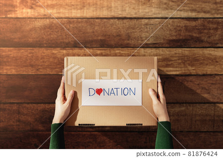 Donation Concept. Woman with Box of Things with Donate label and Heart 81876424