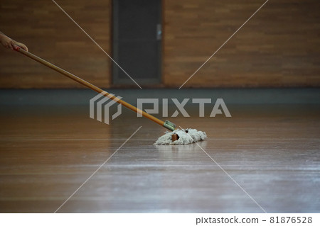 Volleyball player mopping the main floor of the gymnasium 81876528