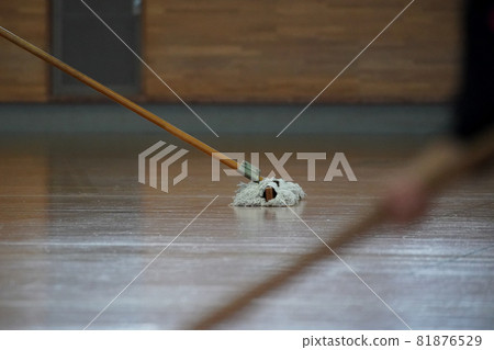 Volleyball player mopping the main floor of the gymnasium 81876529