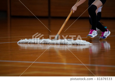Volleyball player mopping the main floor of the gymnasium Volleyball player mopping the main floor of the gymnasium 81876533