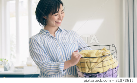 A smiling woman with a laundry basket 81878615