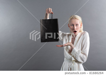 white caucasian albino blond woman holds black shopping bags. Sale and discounts on market and Black Friday concept. 81880264