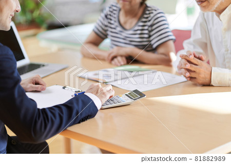 At hand of a real estate salesman who calculates with a calculator At hand of a real estate salesman who calculates with a calculator 81882989