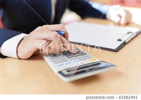 At hand of a salesman who calculates with a calculator At hand of a salesman who calculates with a calculator 81882991