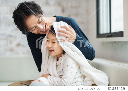 Dad and daughter wiping their hair with a bath towel Dad and daughter wiping their hair with a bath towel 81883419