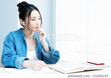 Young woman studying with earphones 81884285
