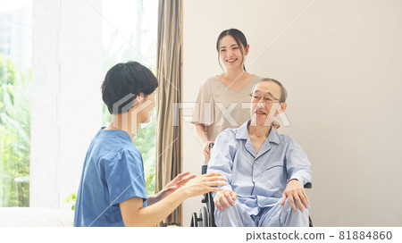 Key worker talking to a senior man in a wheelchair 81884860