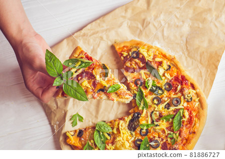Pizza and hand close up over white background Pizza and hand close up over white background 81886727
