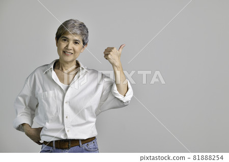 Asian woman pointing fingers up at empty copy space for text isolated on white background Asian woman pointing fingers up at empty copy space for text isolated on white background 81888254
