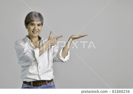 Asian woman showing empty copy space on the open hands palm for text or product isolated on white Asian woman showing empty copy space on the open hands palm for text or product isolated on white 81888256