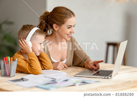 Happy mother supporting son during online studies Happy mother supporting son during online studies 81888280