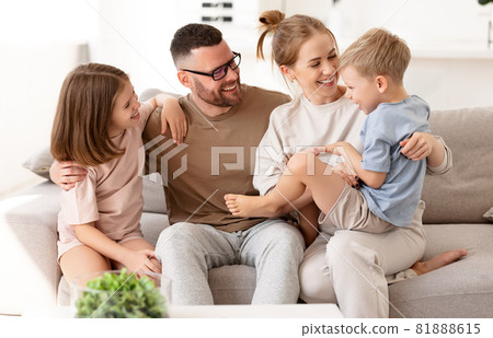Happy beautiful family having fun and playing while relaxing on sofa in living room 81888615