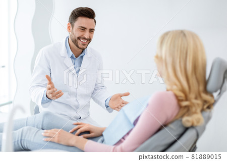 Friendly dentist having conversation with blonde woman patient 81889015