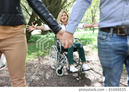 Disabled woman in wheelchair screaming and crying in front of couple leaving her Disabled woman in wheelchair screaming and crying in front of couple leaving her 81889835