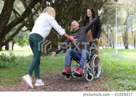 Disabled man in wheelchair walking in park with nurse and hugging his girlfriend Disabled man in wheelchair walking in park with nurse and hugging his girlfriend 81889837