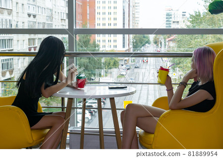 two teenage girls drinking a cocktail in the cafeteria two teenage girls drinking a cocktail in the cafeteria 81889954