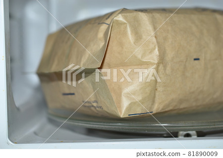 A bag of popcorn in the microwave to cook 81890009
