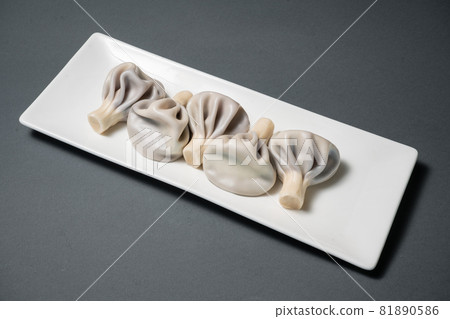 blueberry khinkali or georgian dumplings with meat on plate on black background blueberry khinkali or georgian dumplings with meat on plate on black background 81890586