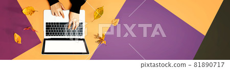 Autumn leaves with person using a laptop computer Autumn leaves with person using a laptop computer 81890717