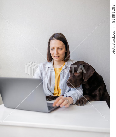 happy european woman and her labrador retriever dog at home 81891288