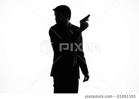 The man in a suit gun in the hands of the emotions silhouette light background The man in a suit gun in the hands of the emotions silhouette light background 81891393