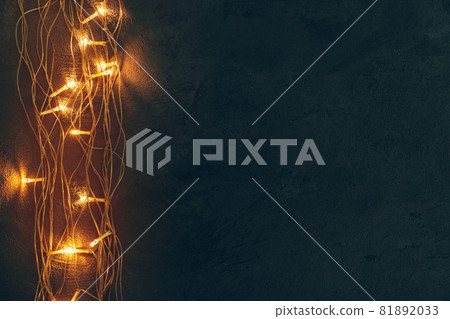 Warm light illuminated garland close up on dark background 81892033