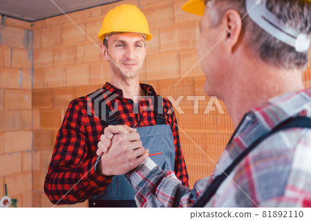 Male construction engineer and builder shaking hands 81892110