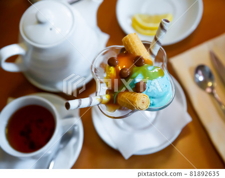 Dessert of two scoops of ice cream, waffle and chocolate candy Dessert of two scoops of ice cream, waffle and chocolate candy 81892635