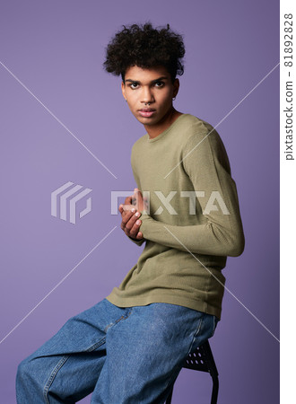 Portrait young transgender man sits in studio. Sexy male with black curly hair 81892828