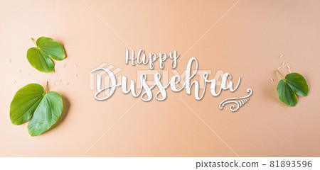 Happy Dussehra. Green leaf with the text on orange pastel background. Dussehra Indian Festival concept. Happy Dussehra. Green leaf with the text on orange pastel background. Dussehra Indian Festival concept. 81893596
