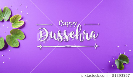 Happy Dussehra. Green leaf and rice with the text on purple pastel background. Dussehra Indian Festival concept. 81893597