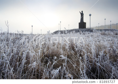 Frosty landscape with hoarfrost on the grass and a monument to St. Nicholas the Wonderworker 81893727