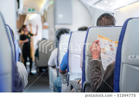 somebody read the menu in the plane, ready order to air hostess. 81894778