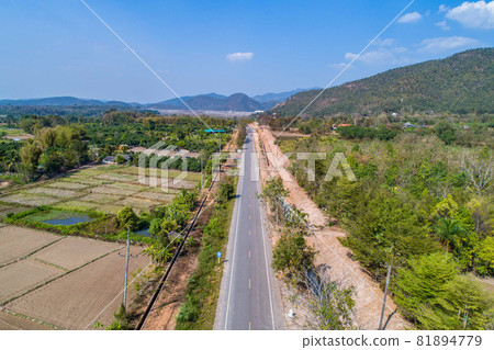 Thailand rural road (shooting from Drone) that the way go to mountain with the field and valley beside., North of Thailand. Thailand rural road (shooting from Drone) that the way go to mountain with the field and valley beside., North of Thailand. 81894779