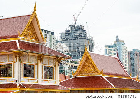 Thai temple in front of urban construction. Representative between religion and urban civilization; building and construction are backround., Bangkok, Thailand. 81894783