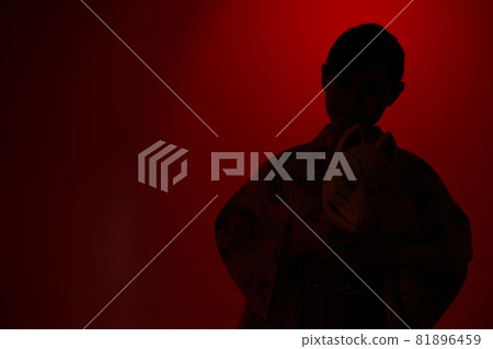 A woman in a yukata holding a fox face in her hand 81896459