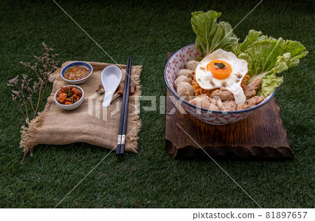 Egg noodles soup with pork ball, minced pork, fried egg, vegetables and soups in bowl. Egg noodles soup with pork ball, minced pork, fried egg, vegetables and soups in bowl. 81897657