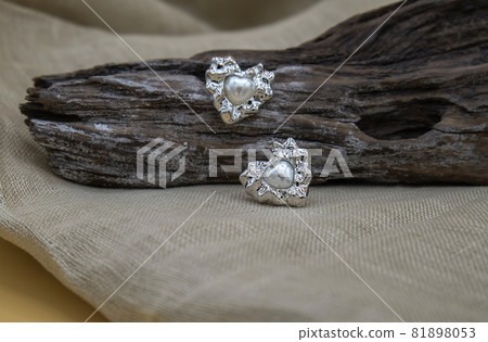Silver jewellery setup. Silver jewelry fashion photography. Silver earrings fashion photography. Earrings presented on a timber. Silver jewellery setup. Silver jewelry fashion photography. Silver earrings fashion photography. Earrings presented on a timber. 81898053