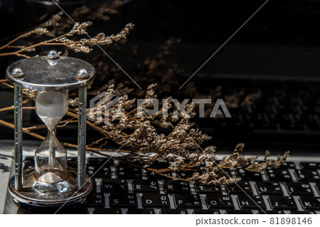 Hourglass on laptop keyboard. Time management concept. Hourglass on laptop keyboard. Time management concept. 81898146