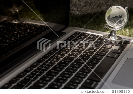 Glass crystal globe on Laptop keyboard. Glass crystal globe on Laptop keyboard. 81898150