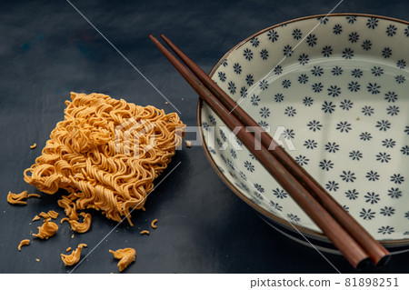 Dried instant noodles and hot water in a bowl. Dried instant noodles and hot water in a bowl. 81898251