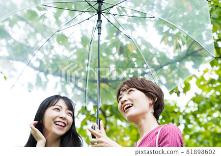 漫步在多雨公園的兩名婦女 漫步在多雨公園的兩名婦女 81898602