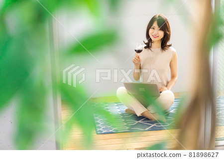 Young woman having a video chat over a glass of wine Young woman having a video chat over a glass of wine 81898627