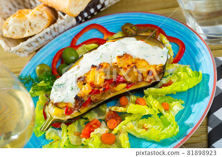 Tasty eggplant stuffed with vegetables and cheese 81898923